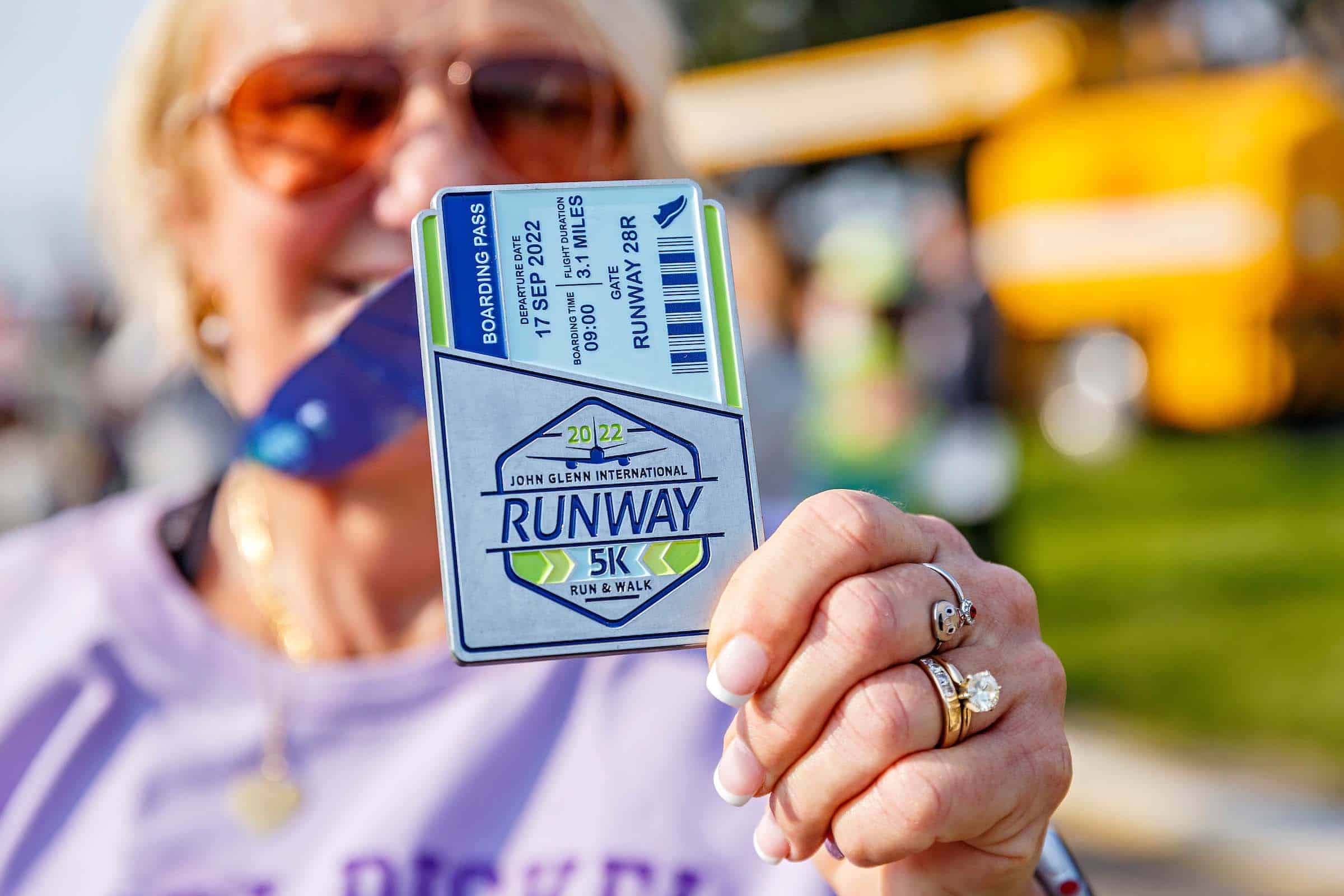 Closeup of a runner at the 2022 John Glenn International Runway 5K Run & Walk, showcasing the 5K boarding pass lanyard.