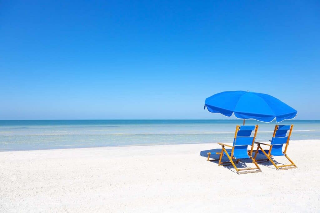 Blue Lounge Chairs and an Umbrella on a Beach