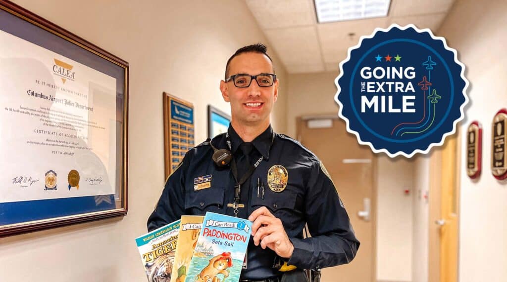 Sgt. Tod Hunter, CRAA employee holding three kids books.