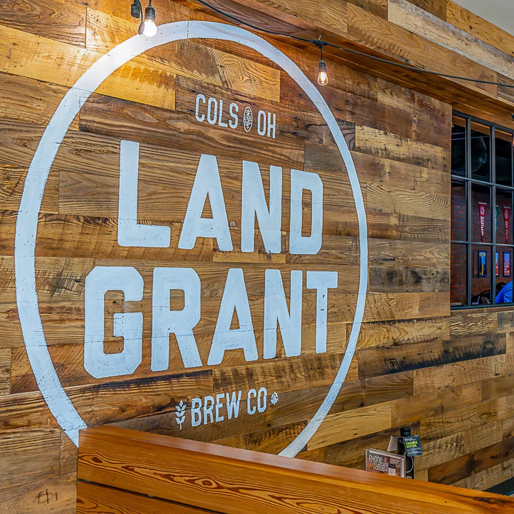 A bar at CMH Airport with a sign that says Land Grant Brew Co.