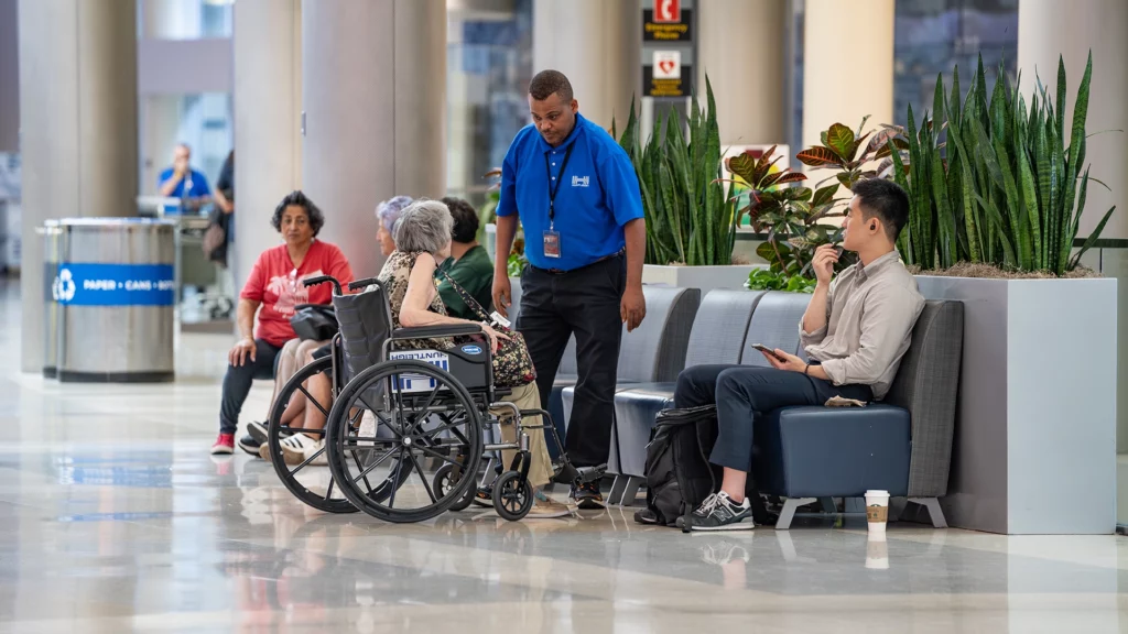 A man in a wheelchair getting accessibility assistance at CMH Airport.