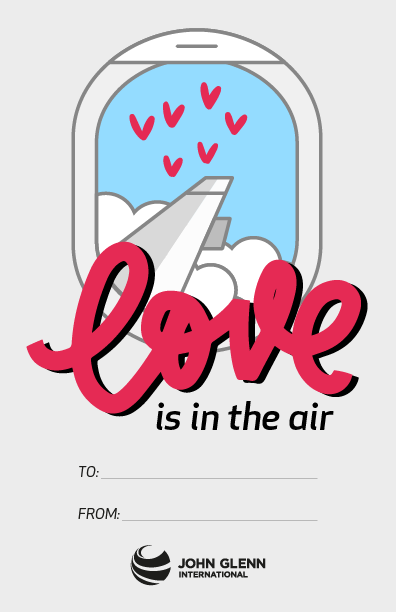 A Valentine's Day card showing clouds and hearts in the sky out of an airplane window. Text reads, "love is in the air."