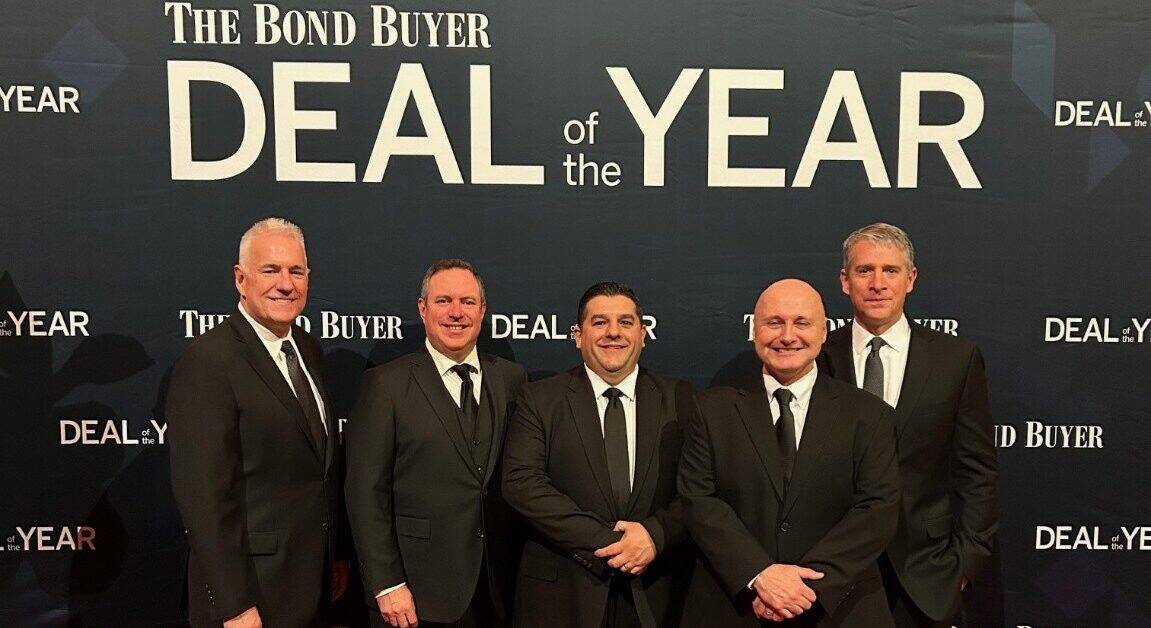 Joseph R. Nardone, President & CEO; William Case, Managing Director, Business Development, PFM; Fabio Spino, Chief Financial Officer; Tom McCarthy, Chief Planning & Engineering Officer; and Kevin McPeek, Director, PFM pose together on a red carpet in front of a Bond Buyer Deal of the Year wall.